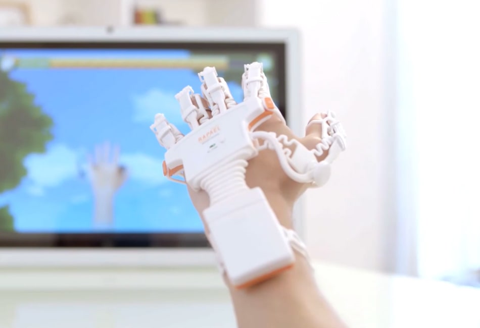 Rękawica Neofect smart glove założona da dłoni Pacjenta, który gra w grę na telewizorze jednocześnie ćwicząc dłóń.