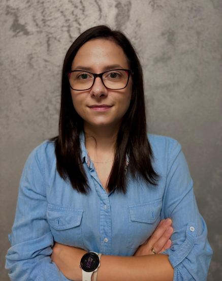 Zdjęcie portretowe Konrada Wiecierzewskiego - młody mężczyzna o brązowych krótkich włosach. Białej koszuli i jasno niebeskiej marynarce..